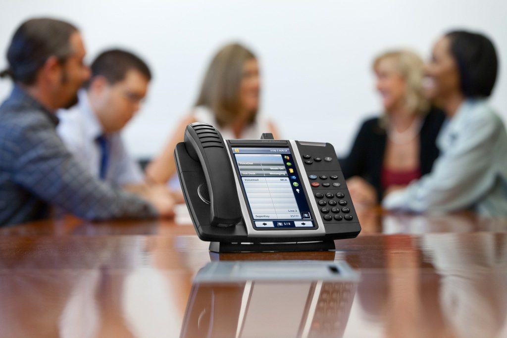 Business professional using a VoIP phone system in a Miami office